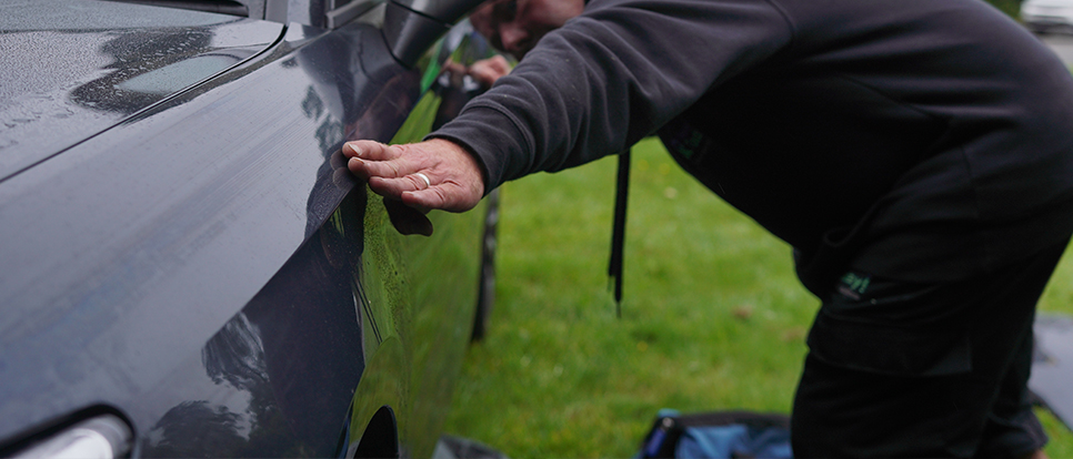 Guaranteed Quality Mobile technician checking panel of car is on correctly