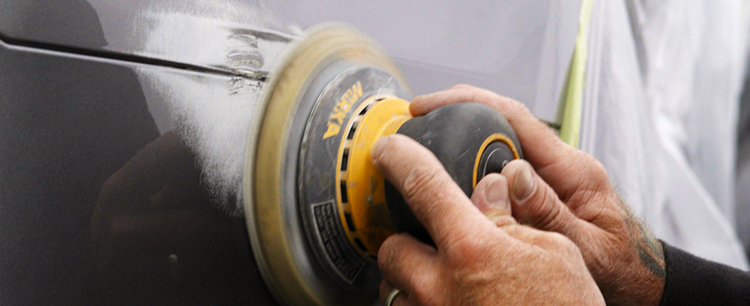 Close up of technicians hand buffing car panel