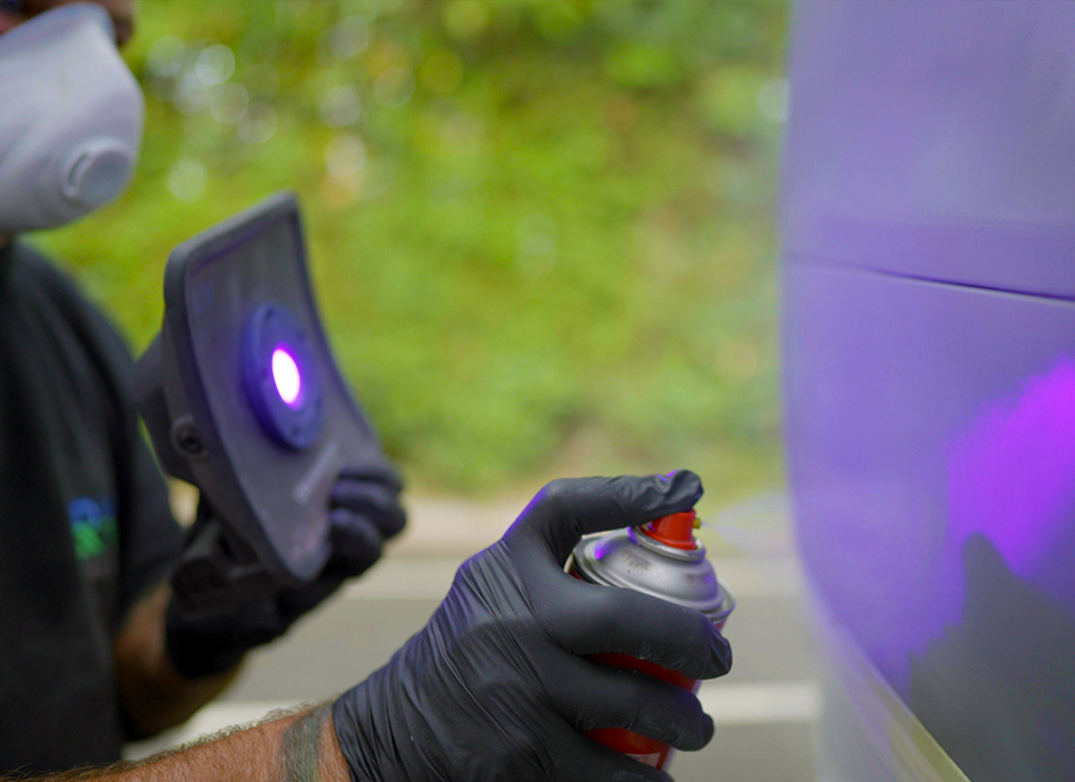 rrn_mobile-car-wing-mirror Close up of technicians hand spray painting car panel